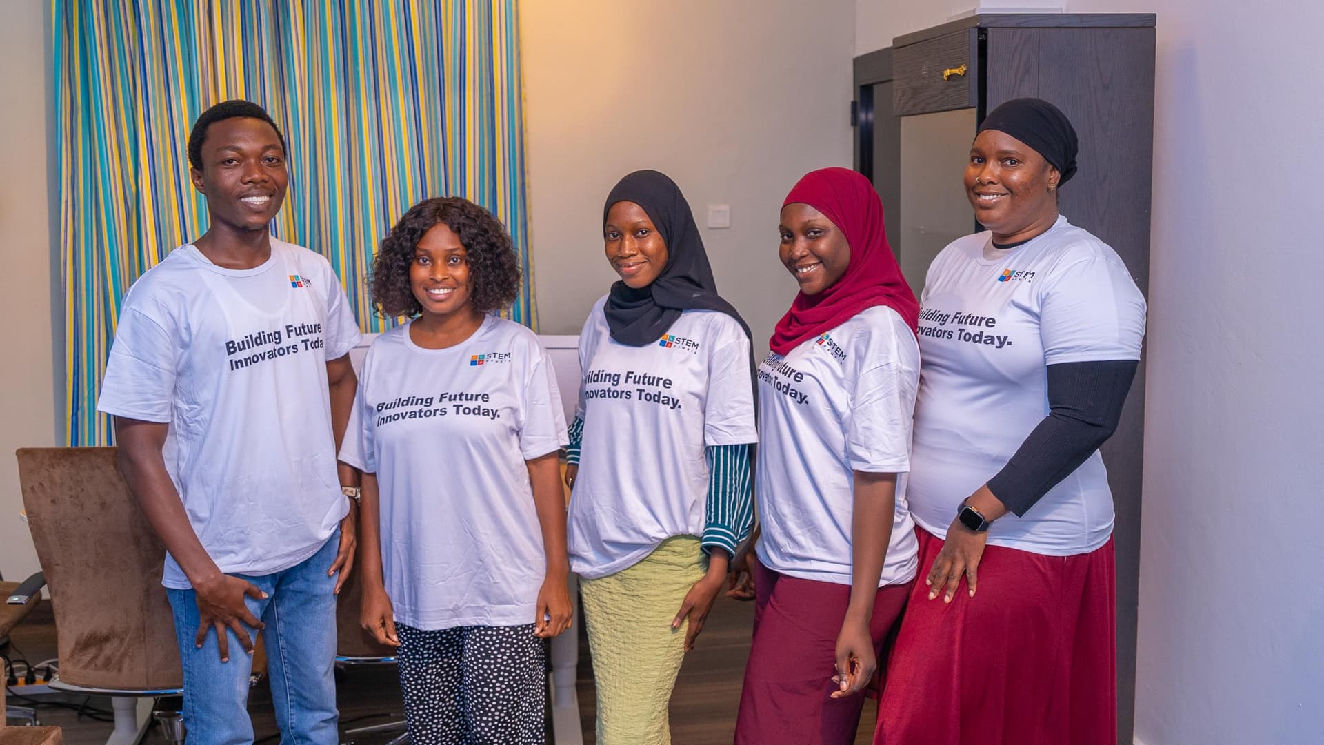 Coders Clutch team members in branded T-shirts standing together in the office