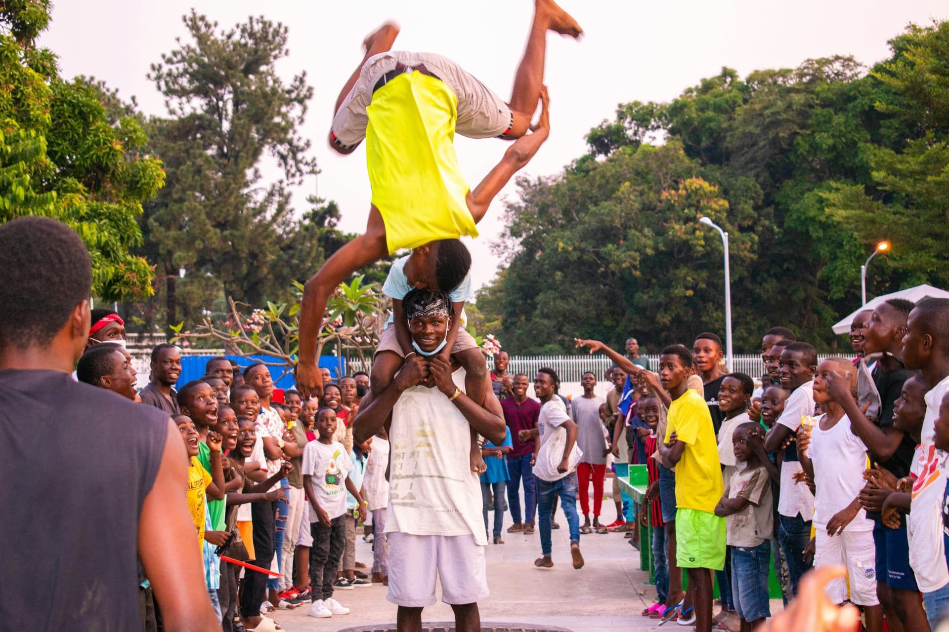 Crowd watching a street acrobat perform a flip