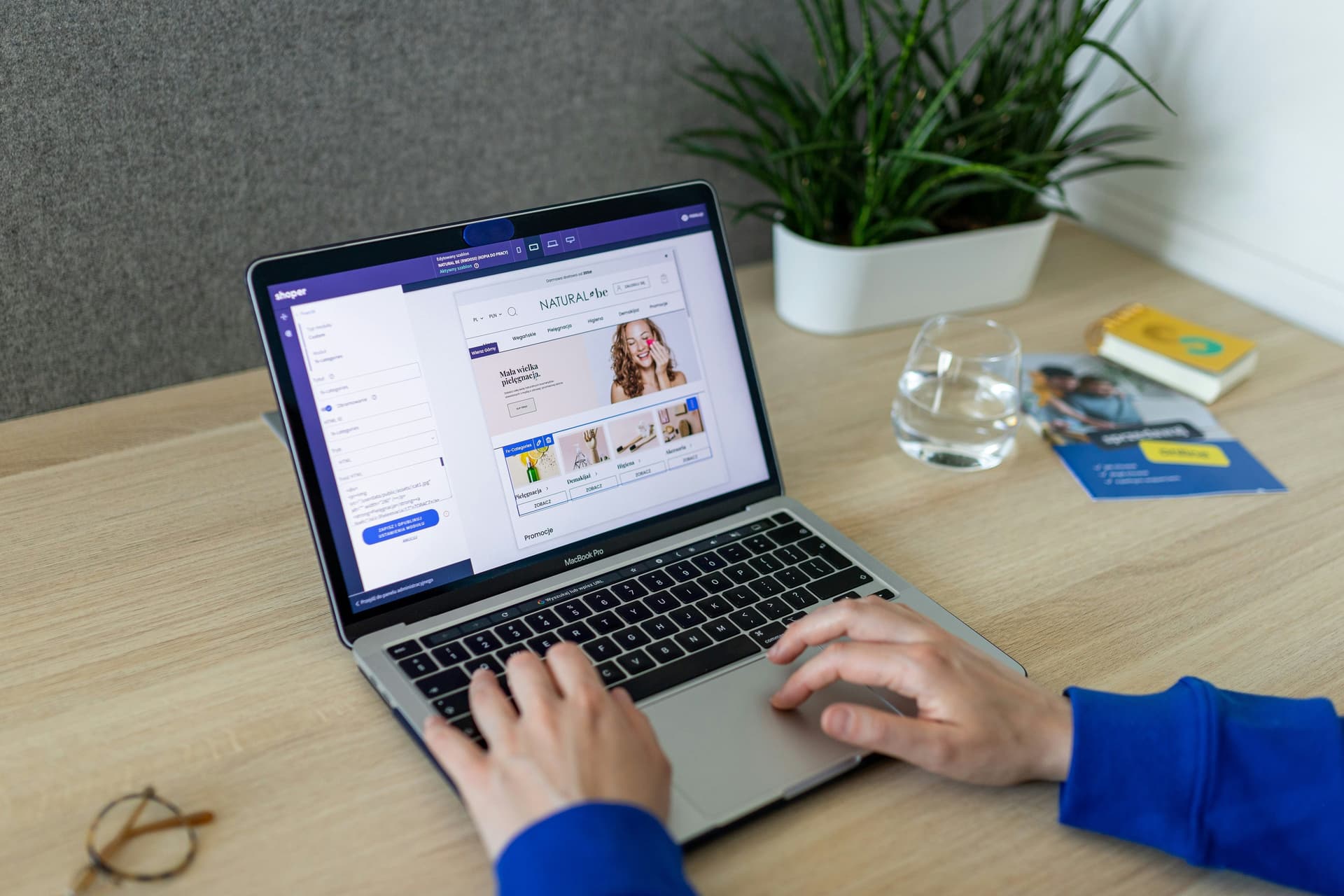 Hands typing on a laptop showing an online shop