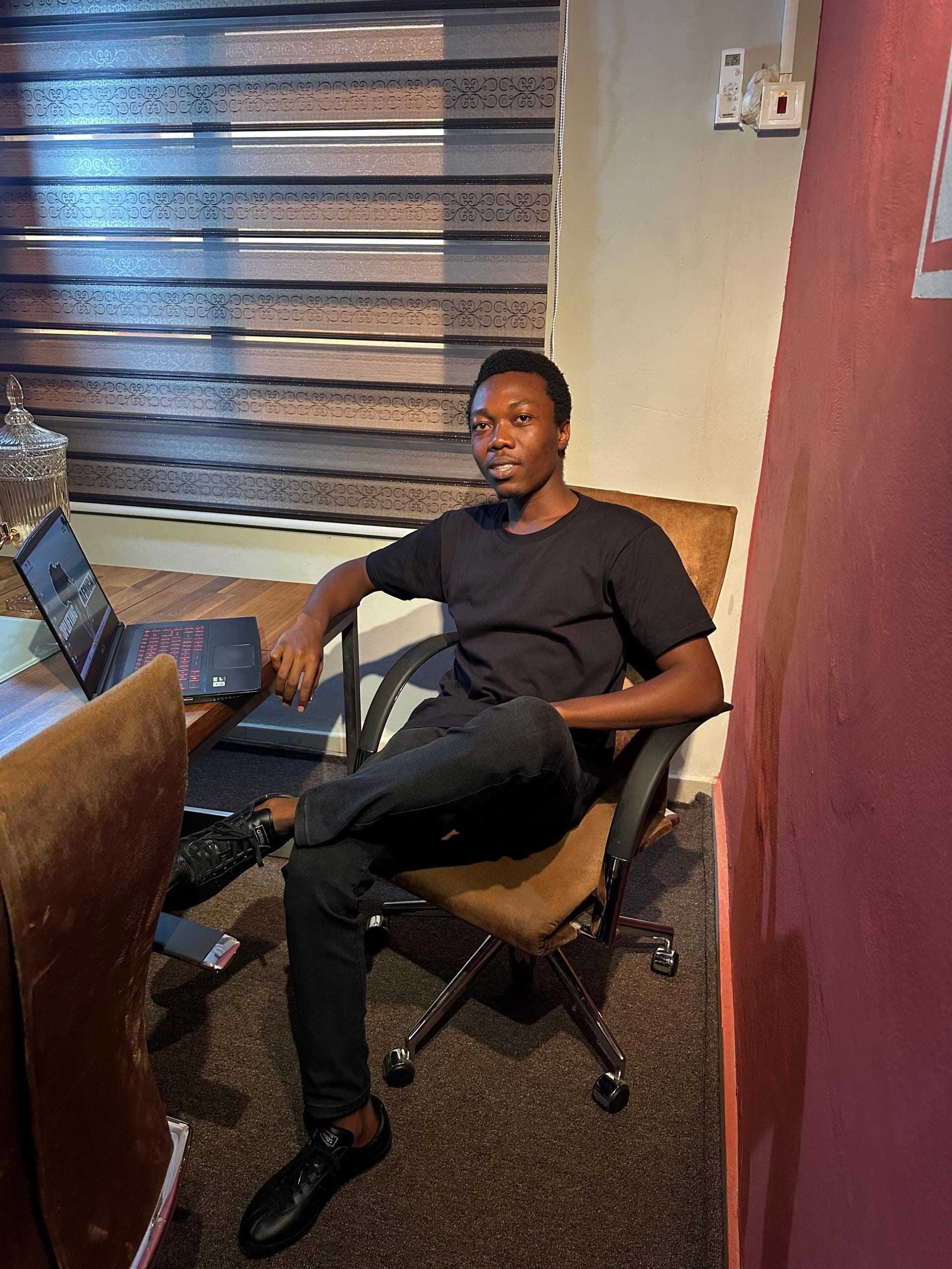 Team member seated in a meeting room with a laptop