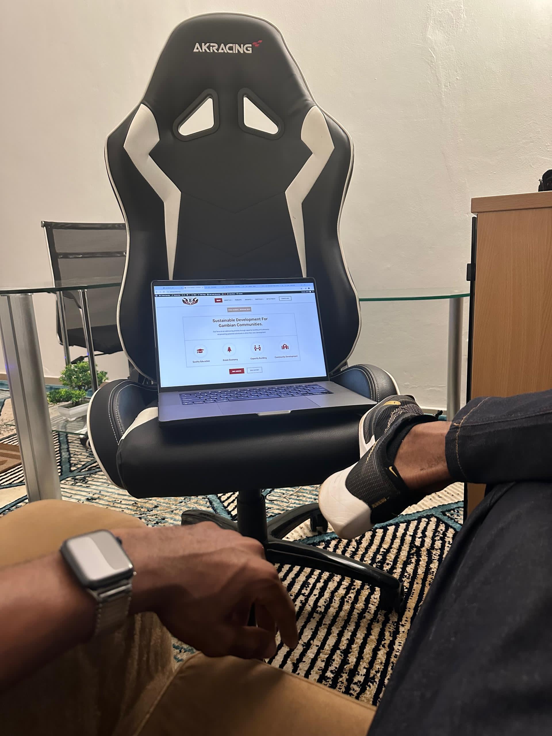 Laptop on a gaming chair showing a web app login screen