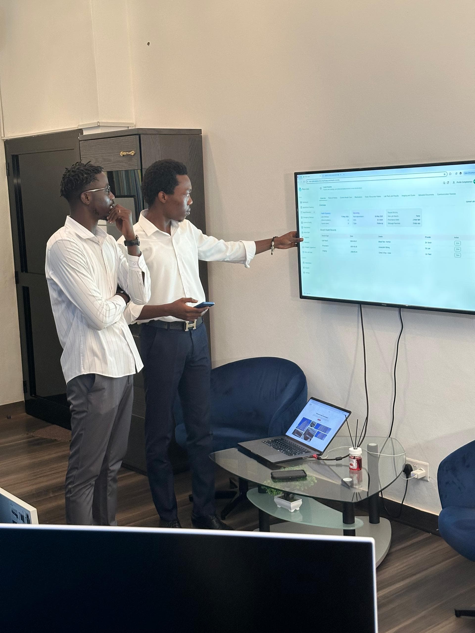 Two colleagues discussing a dashboard on a wall screen